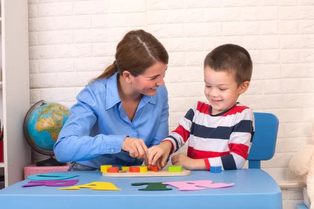 彼女のセラピストと感覚の遊び心のある演習を行う子供の作業療法セッションで幼児の男の子。