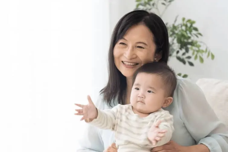 赤ちゃん抱っこする高齢の女性